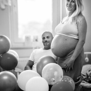 Babyshooting zuhause im Babyzimmer mit dem Partner und vielen Babyaccessoires
