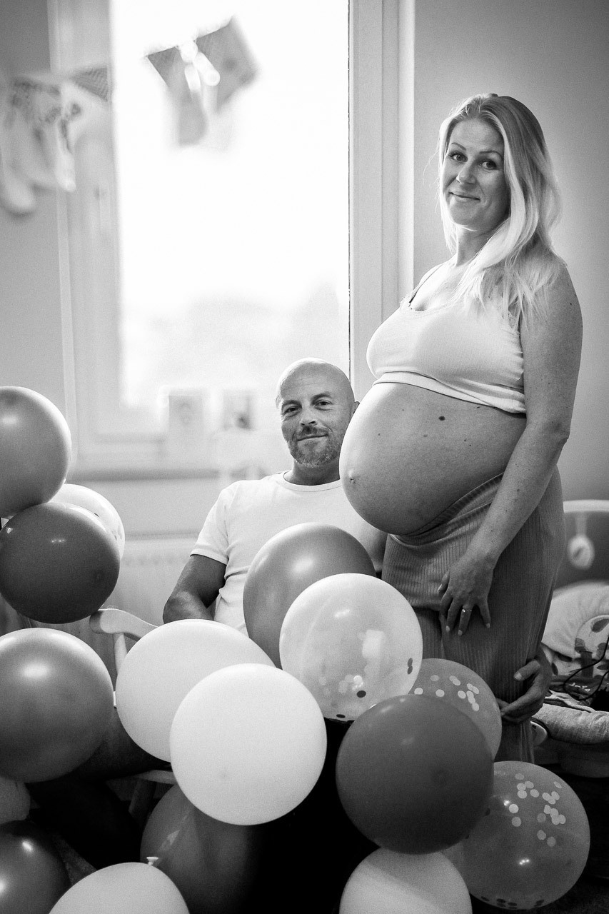 Babyshooting zuhause im Babyzimmer mit dem Partner und vielen Babyaccessoires